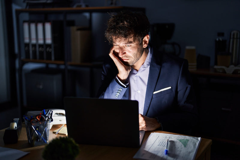 Man working late at a laptop in a dark office